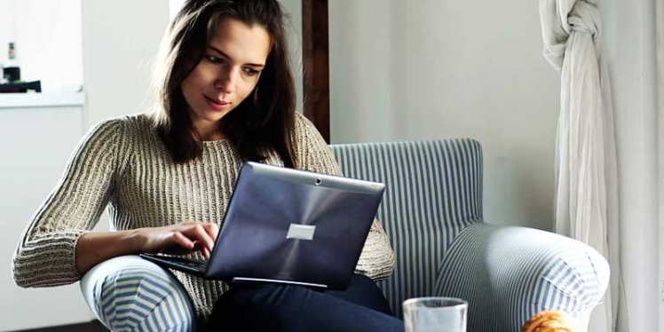 stock-footage-woman-sit-in-armchair-and-typing-on-modern-laptop-at-home
