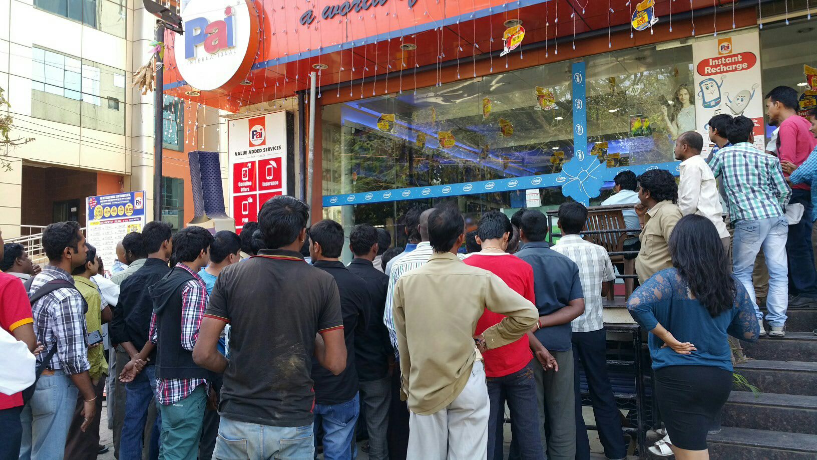 Crowd watching cricket match outside shop